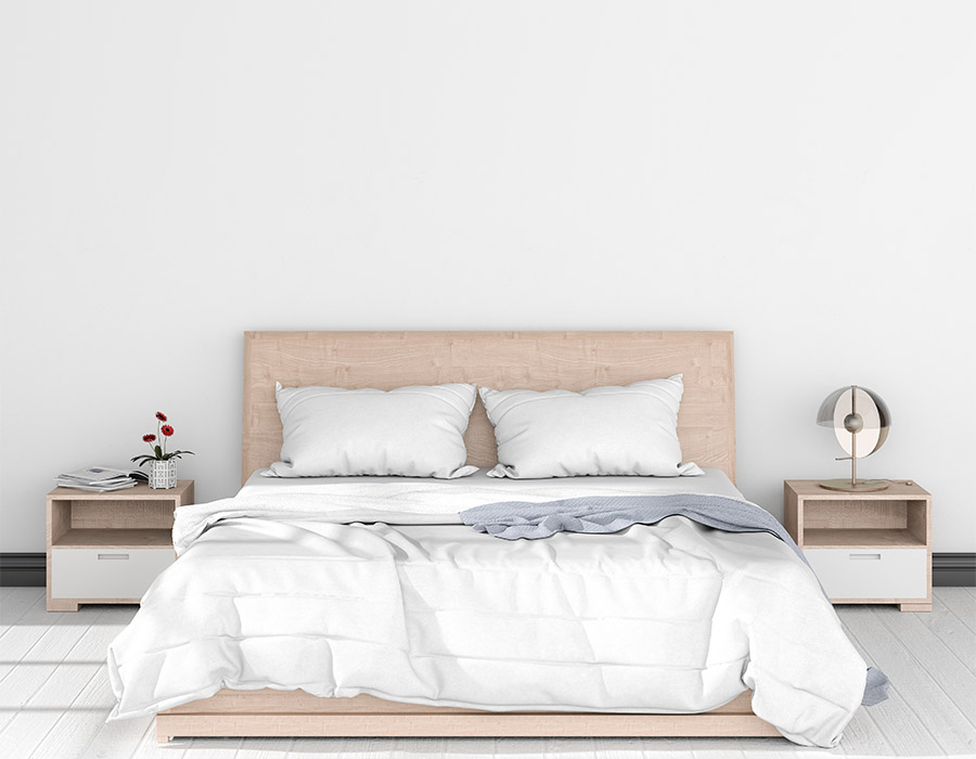 Sábanas ecológicas: vista frontal de una cama vestida con sábanas ecológicas de algodón orgánico. Cabezal de madera natural a juego con las mesitas de noche. Suelo de madera blanca en el mismo tono que la pintura de la pared.